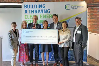 UMass Lowell officials accept a check from state officials.
