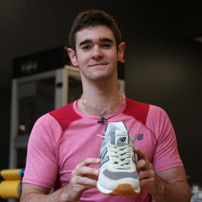 UMass Lowell student Matt Macioci holding New Balance sneaker