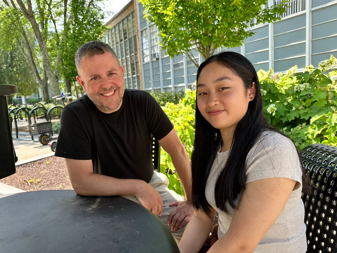 Visiting Lecturer Matthew Beyranevand, left, and student researcher Melanie Khiem outdoors in front of trees