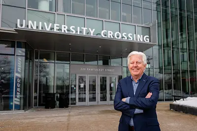 Marty Meehan standing in front of University Crossing on UMass Lowell's campus.