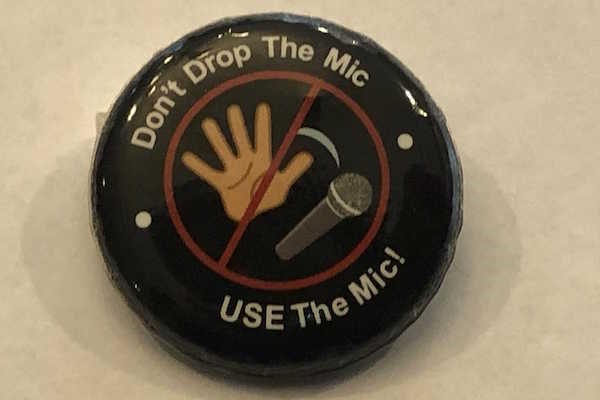 Round black button that says "Don't drop the mic, USE the Mic!"