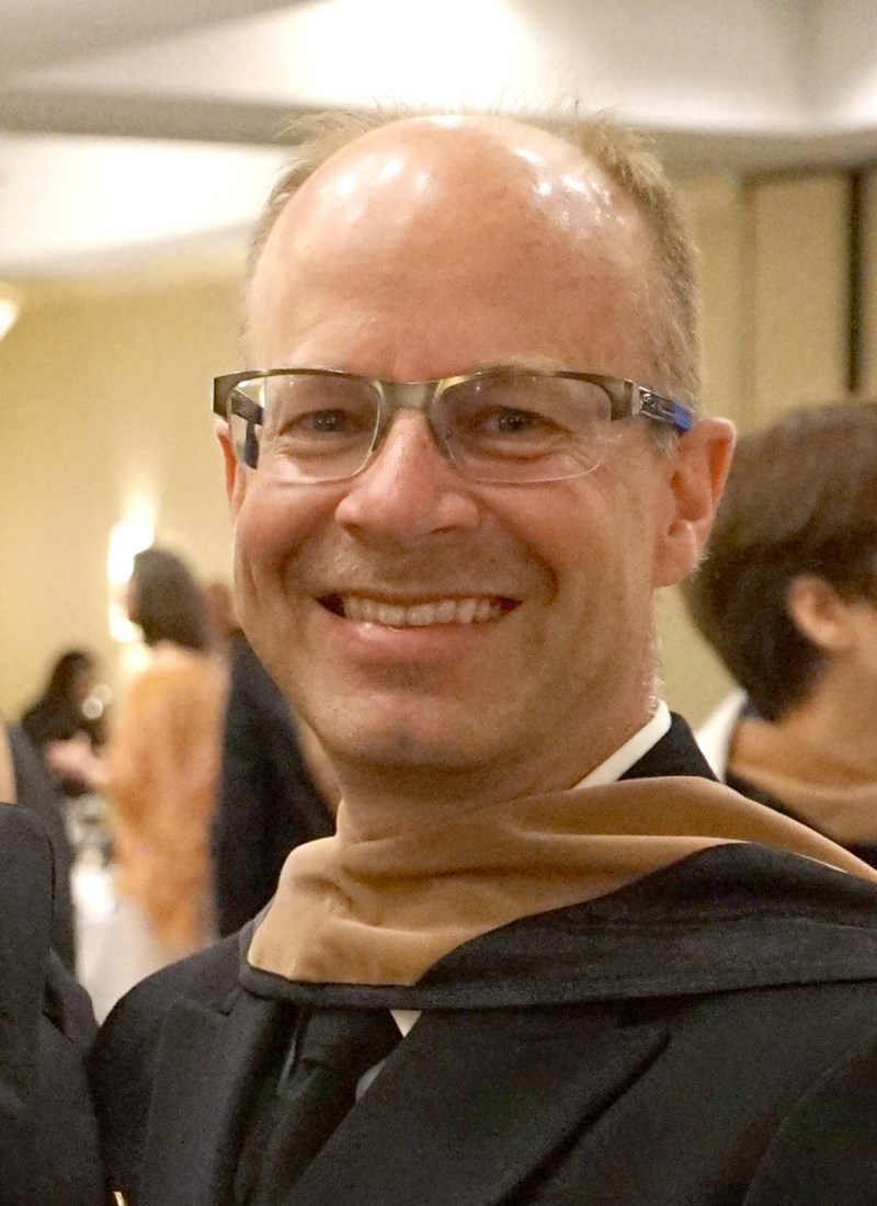 headshot of Mike Taskoski in graduation gown and hood
