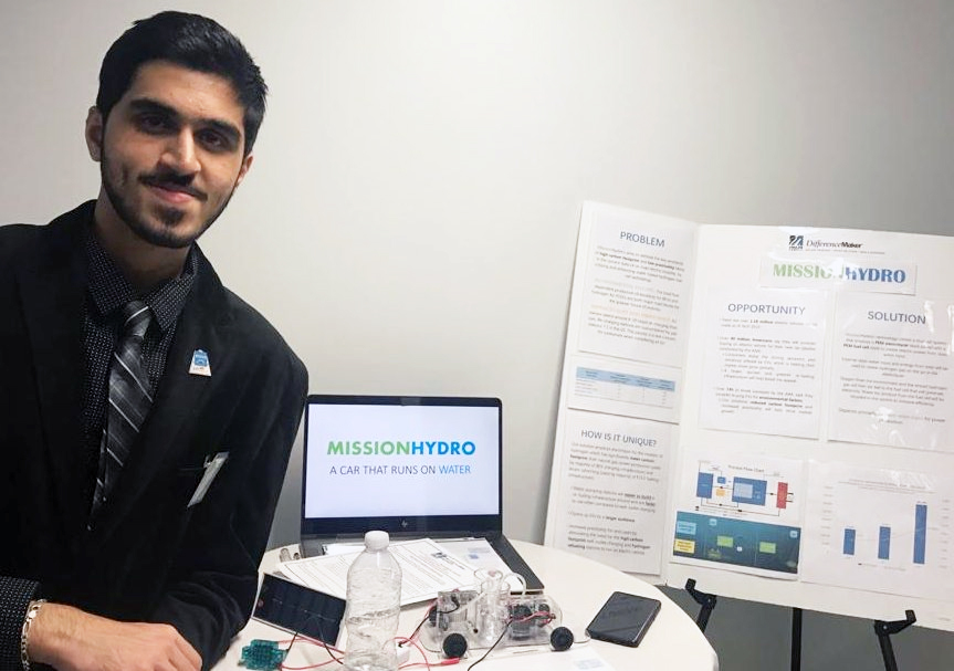 Sarvesh Handa standing with his project's prototype and idea plan model.