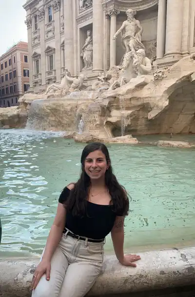Montana Heise sitting in front of the Trevi Fountain in Rome.