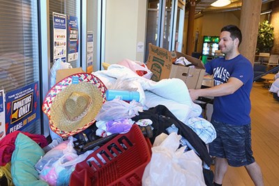 A student leaves a box in the donation collection bin at River Hawk Village