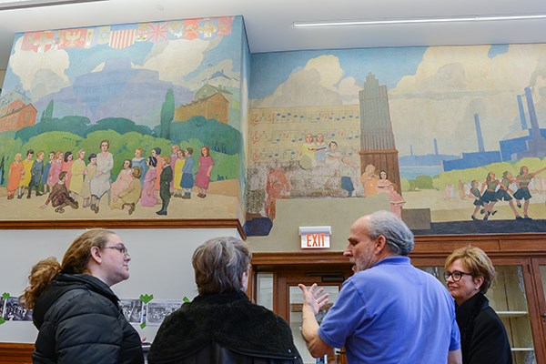 Conservator Gianfranco Pocobene, second from right, discusses the Coburn Hall murals with Chancellor Jacquie Moloney, right, and others.