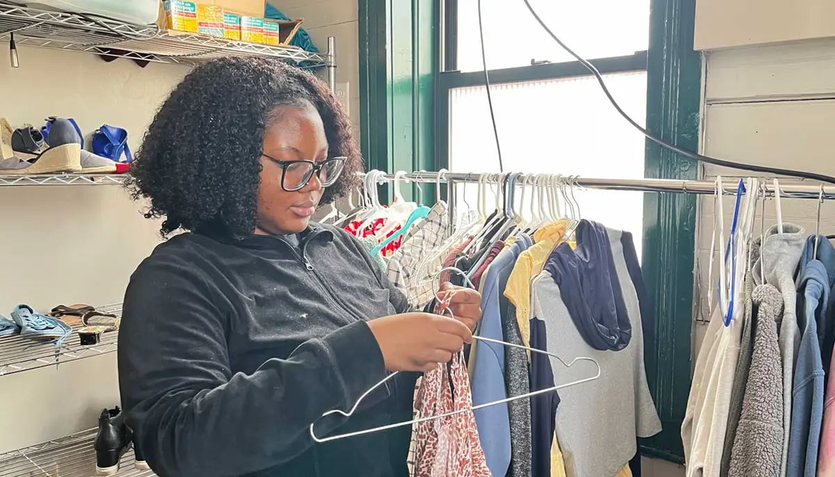 Nadia Eshun puts a shirt on a clotheshanger. 