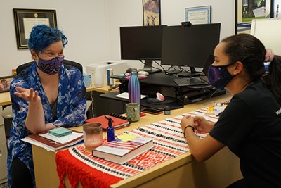 Director of the Office of National Scholarships at UMass Lowell Rae Mansfield, with blue hair, talks to English major and student Carolina Reyes