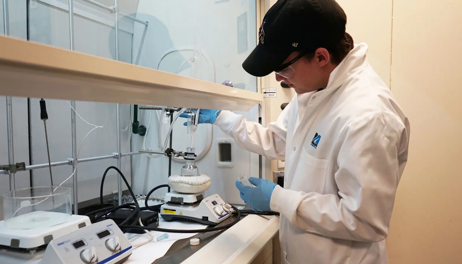 Chemistry student, Noah Mason, using a pipette in a lab. 