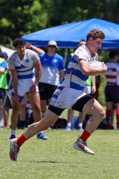A rugby player runs with the ball during a game