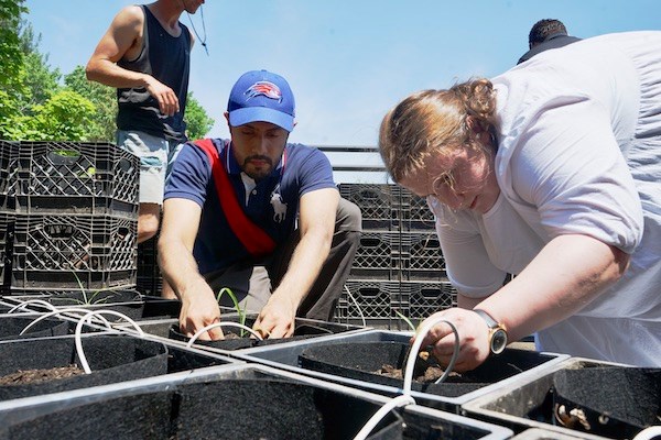 Two students help containers at the rooftop garden