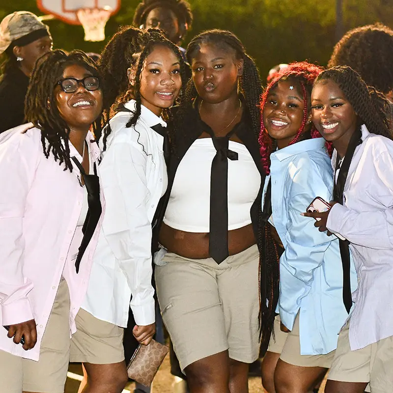 Five women pose on campus at night during Afropalooza.