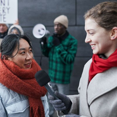 Woman with microphone interviewing other woman
