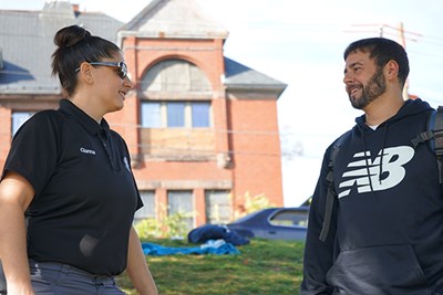 Gianna Sandelli '19, '22 speaks with bilingual outreach worker Derek Sampson near the Lowell Office of Community Counseling, which offers services to people with substance use disorders