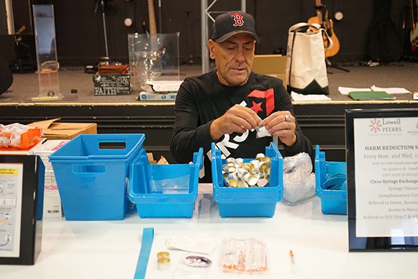 Joe Faria, an outreach worker who also helps with the needle exchange program, prepares safe injection supplies at the Life Connection Center