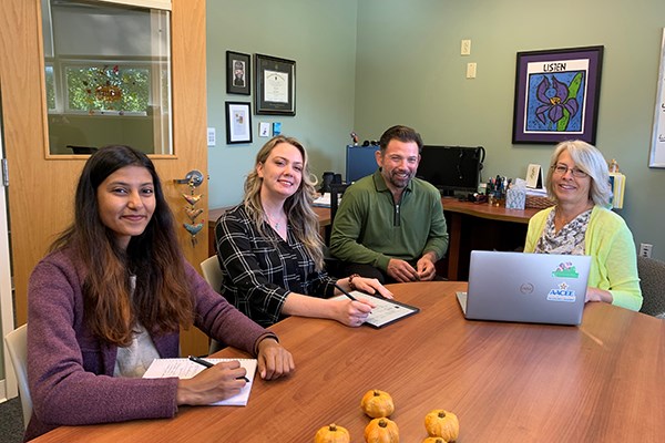 Robin Toof (right), co-director of UML's Center for Community Research and Engagement, and Criminology Assoc. Prof. Wilson Palacios meet with graduate research assistants Shibani Chakravorty (left) and Taylor Sheldon.