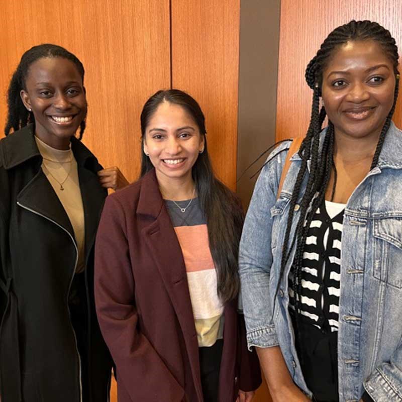 Three public health students pose while attending the Tripathi event