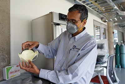 UML Plastics Engineering Prof. Ramaswamy Nagarajan demonstrates a mask that was certified after being tested at the Fabric Discovery Center