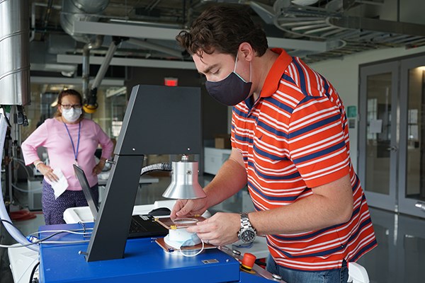 UML engineering technician Patrick Casey tests a mask for aerosol penetration at the Fabric Discovery Center
