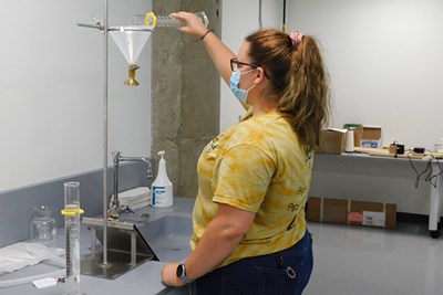 UML Honors College student Madison Reed conducts a pour test on PPE fabric