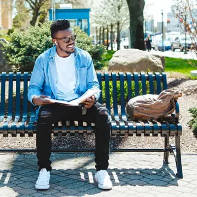 UMass Lowell student sitting on bench outdoors