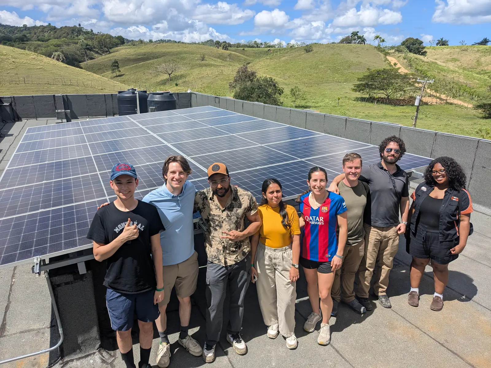 Eight students stand in front of solar panels in the Domincan Republic.