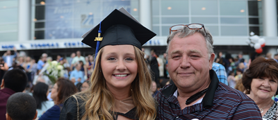 Dad and daughter who is a graduate at commencement
