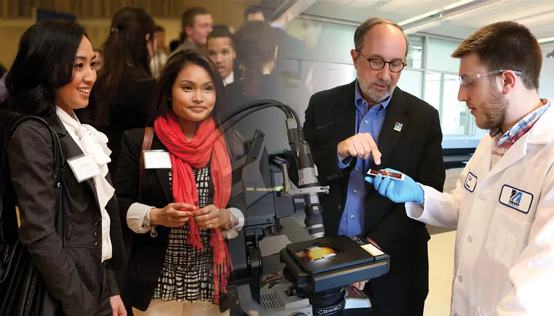 Two women and a man look at equipment in a technician's hand
