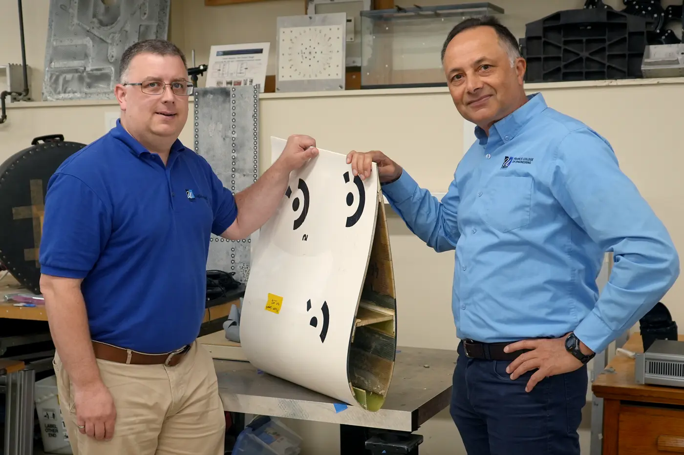 Patrick Drane and Chris Niezrecki hold a segment of a wind turbine blade.