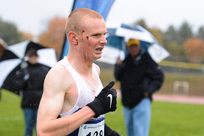 A bloodied Paul Hogan runs at the AE cross country championships