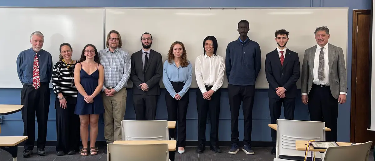 The keynote speaker, Pi Mu Epsilon advisor, and new inductees pose for a group photo at the Pi Mu Epsilon induction ceremony.