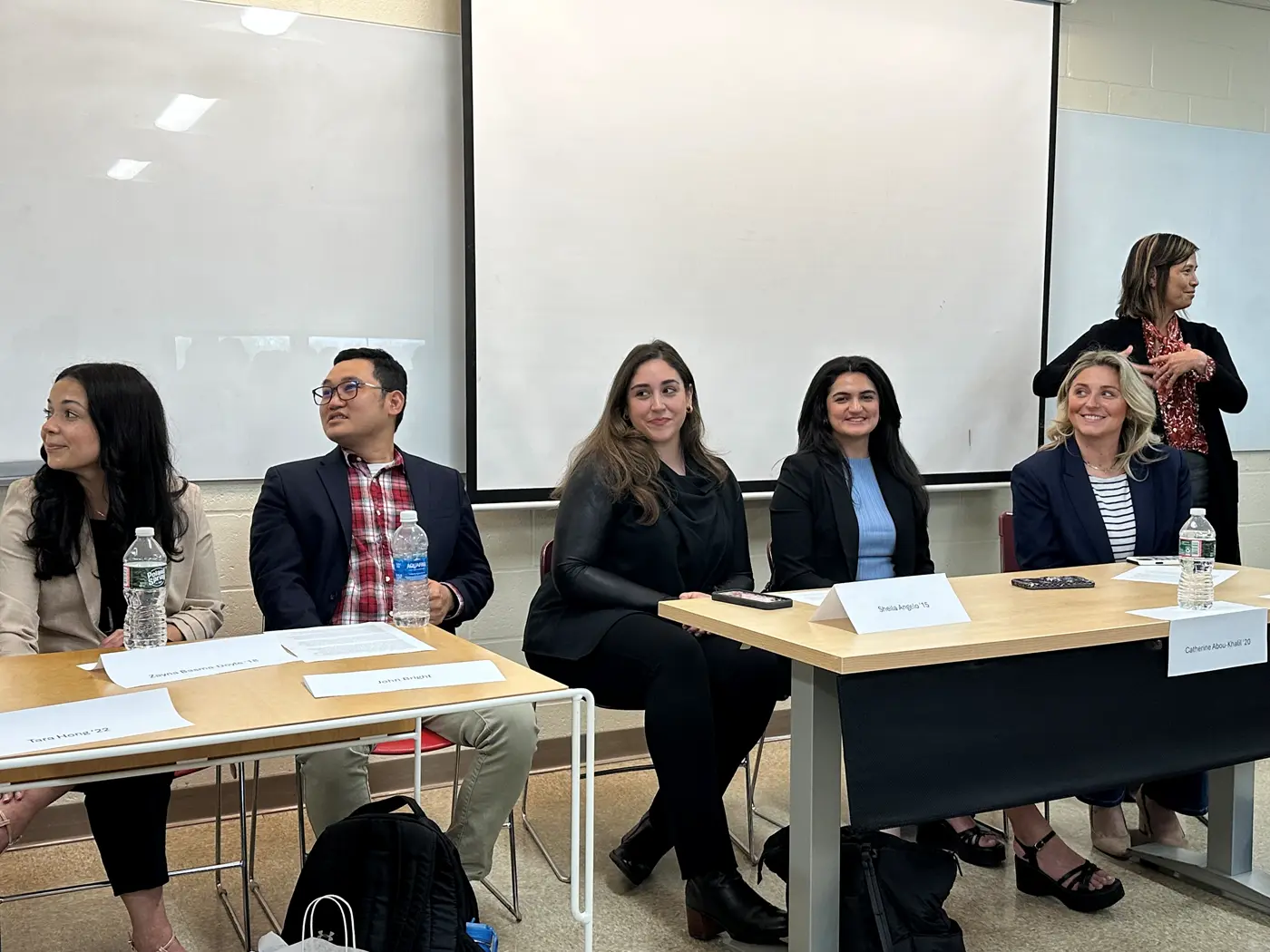 UML alumni sit at tables listening to another alum. Prof. Ardeth Thawnghmung is standing 