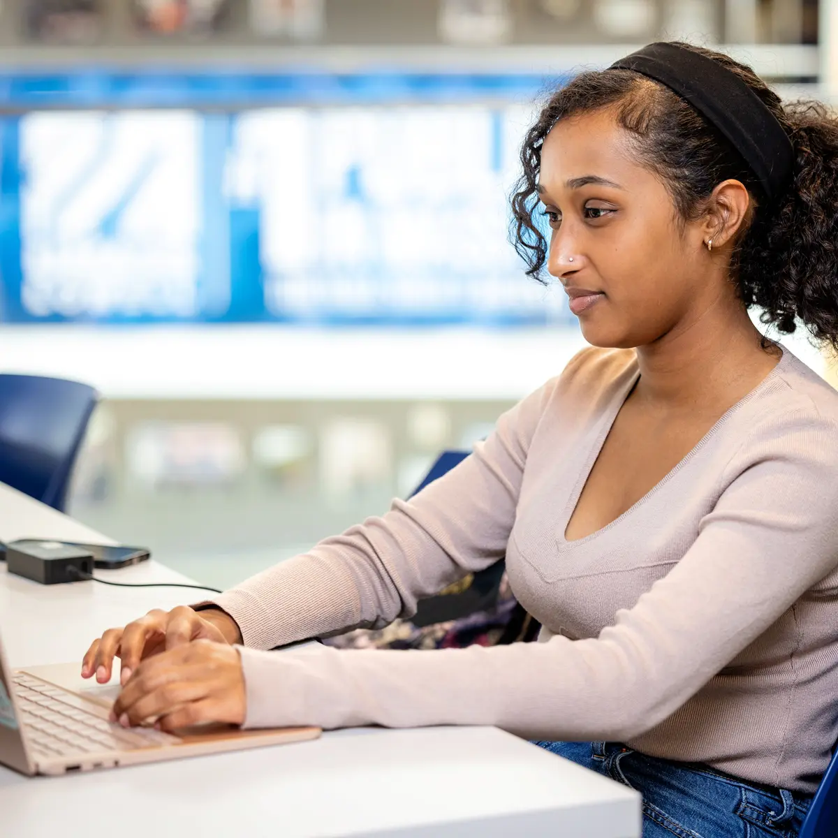 Person sitting at a desk and looking at a computer.
