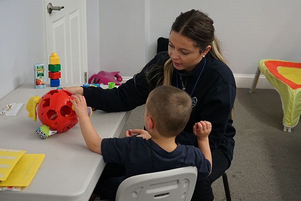 Tabatha Candido '15, '17 works on a task with a preschooler at PrideStar Center for Applied Learning.