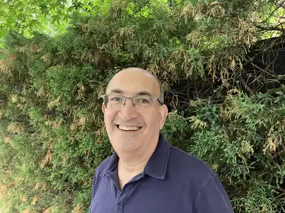 Math Professor James Propp stands in front of a leafy background