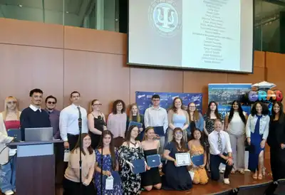 17 psychology students hold up certificates