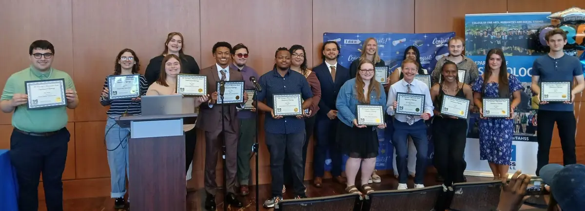 17 psychology students hold up certificates