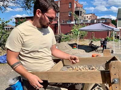 Quintin Blake sifts through dirt and material at the archeological dig at 509 Market Street in Lowell, Mass.