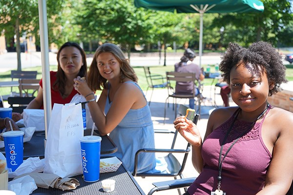 Yrvanie Joseph, right, enjoys the sun during lunch with Junyuan Hu and Katherine Vail, center