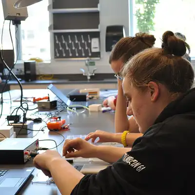 Two young women work on wiring project