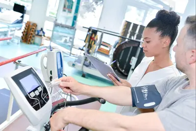 female physio therapist working with male patient on equipment