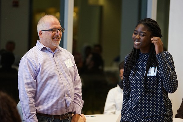Kevin Rourke and mentee Mildred Kumah speak during the dinner