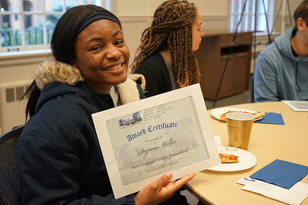 Psychology major and River Hawk Scholar Dejonai Willis displays her scholarship certificate from the Independent Association of University Alumni at Lowell