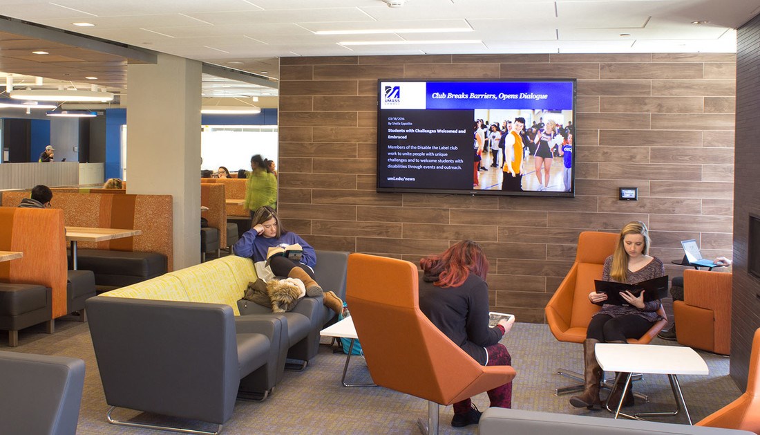 students sitting in couches with a tv monitor on the wall