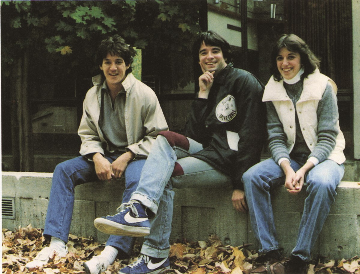 Three students sitting on campus