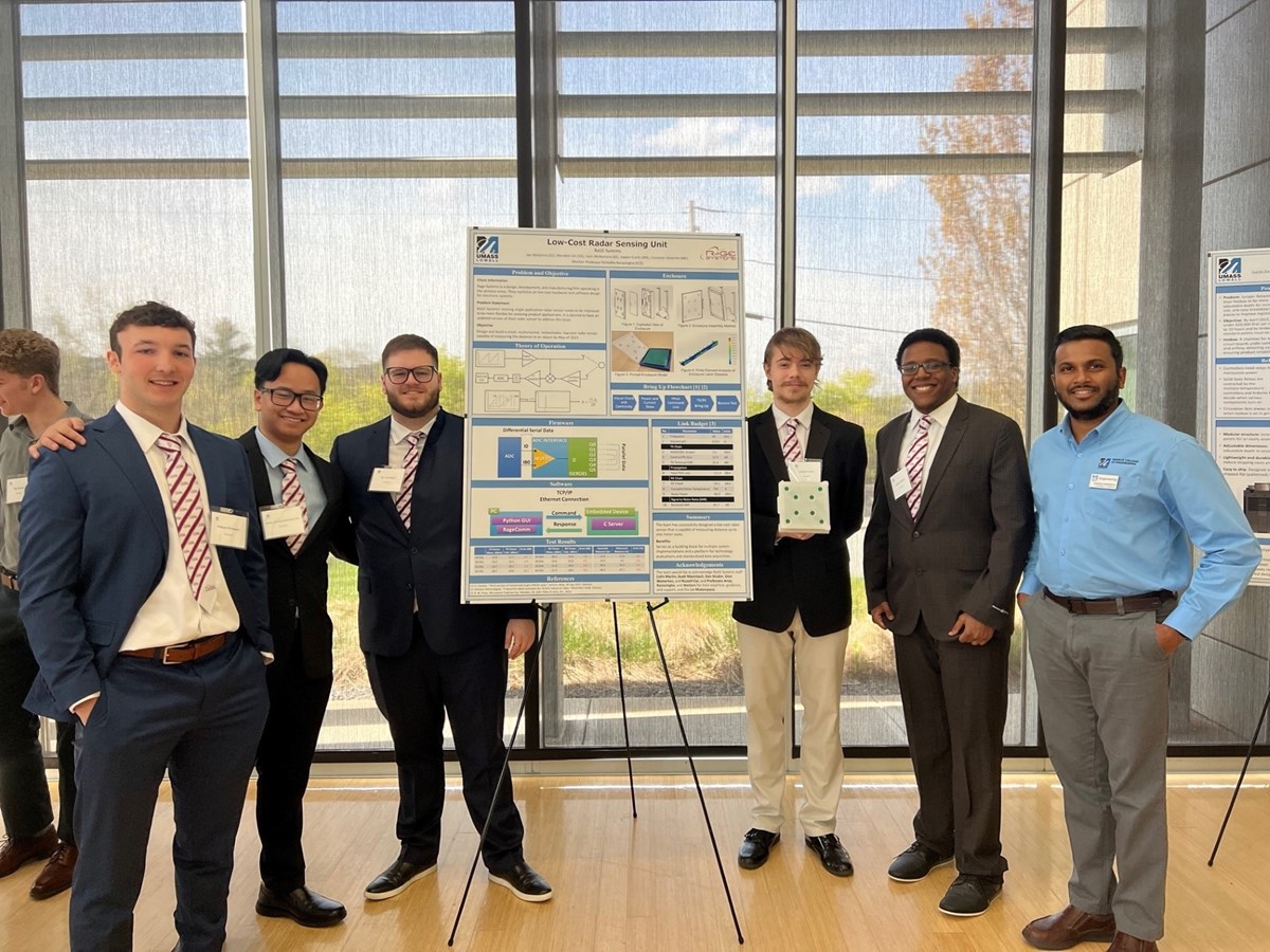 A group of students with a faculty mentor, presenting a poster for their senior project