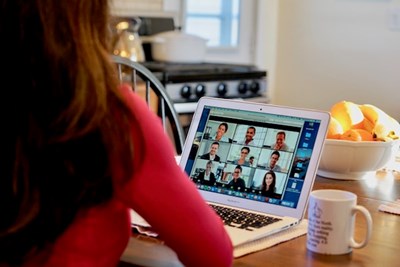 A woman participates in a video conference call from home