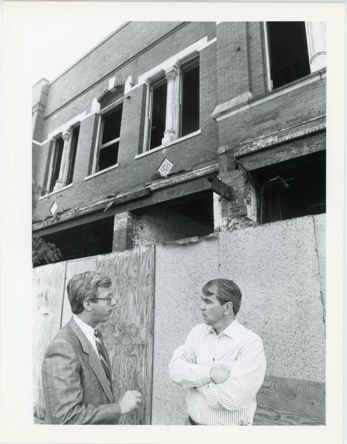 Black and white photo of Peter Aucella standing with Paul Tsongas in front of the Boston and Maine Railway Depot on Central Street.