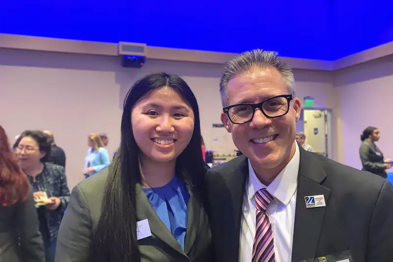 UMass alum and student mentor Richard Juknavorian poses with a student.