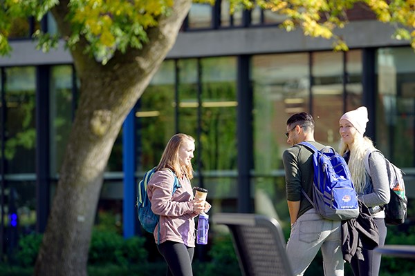 Three students chat on South Campus